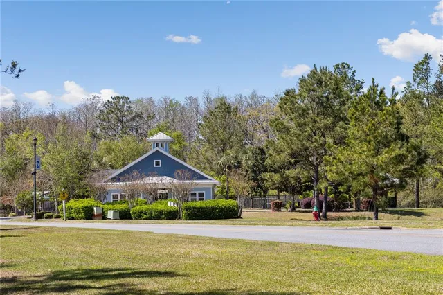a front view of house with yard and trees in the background