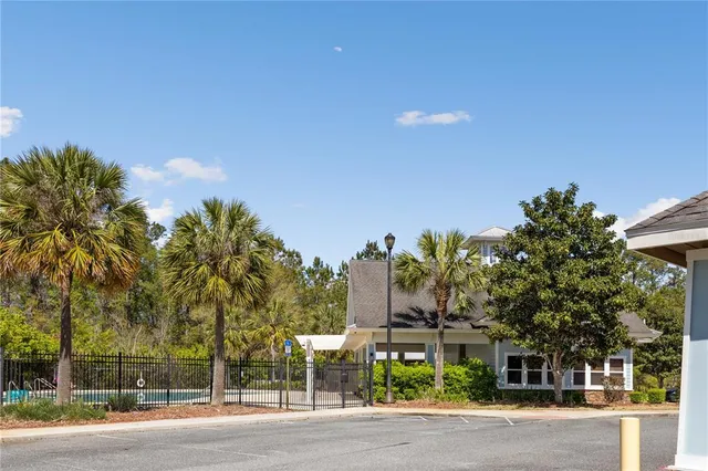 a front view of a house with a yard and tree s