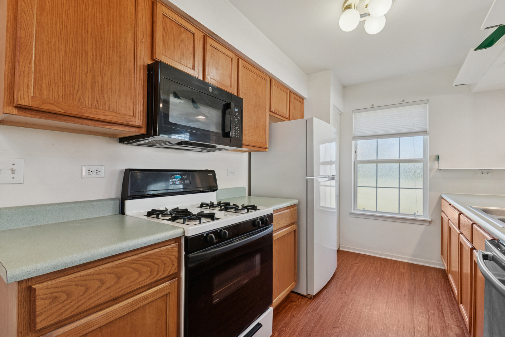 1919 Carousel Court, Unit 1919 Joliet, IL 60435 - Photo 11 of 20 a kitchen with stainless steel appliances a stove a microwave and cabinets