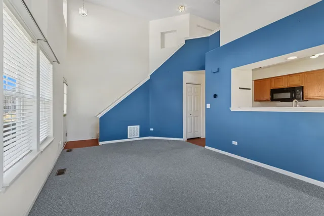 a view of a livingroom with an empty space and a window