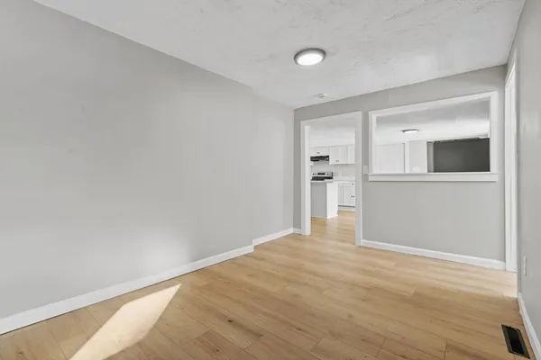 a view of empty room with wooden floor and windows