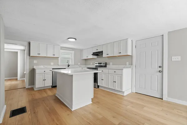 a kitchen with white cabinets and stainless steel appliances