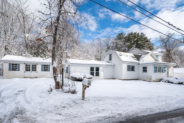 a front view of a house with a yard covered in snow