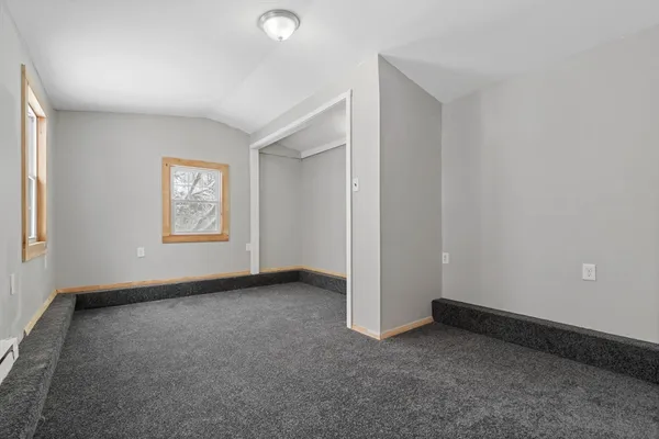 a view of an empty room with a fireplace and a window