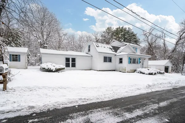 a front view of a house with a snow on the road