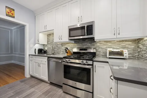 a kitchen with stainless steel appliances granite countertop a stove microwave and sink