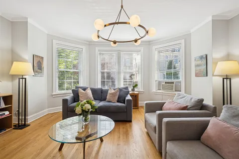 a living room with furniture a table and a large window