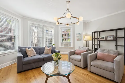 a living room with furniture a window and a chandelier