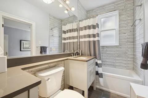 a bathroom with a sink toilet vanity and tub