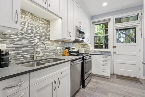 a kitchen with granite countertop a sink stainless steel appliances and cabinets