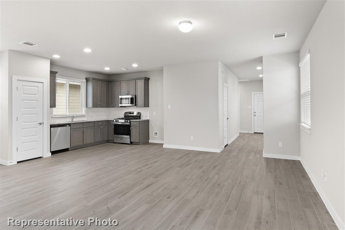 a kitchen with stainless steel appliances granite countertop a refrigerator and a sink