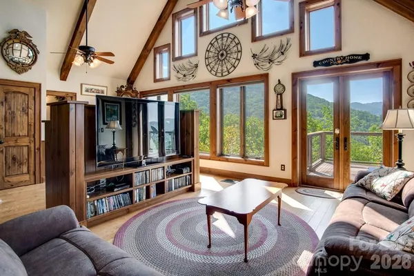 a living room with furniture a bookshelf and a large window