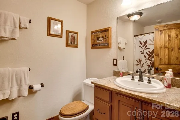 a bathroom with a granite countertop sink a toilet and a mirror