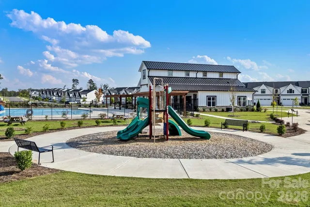 a view of swimming pool with lawn chairs and couches