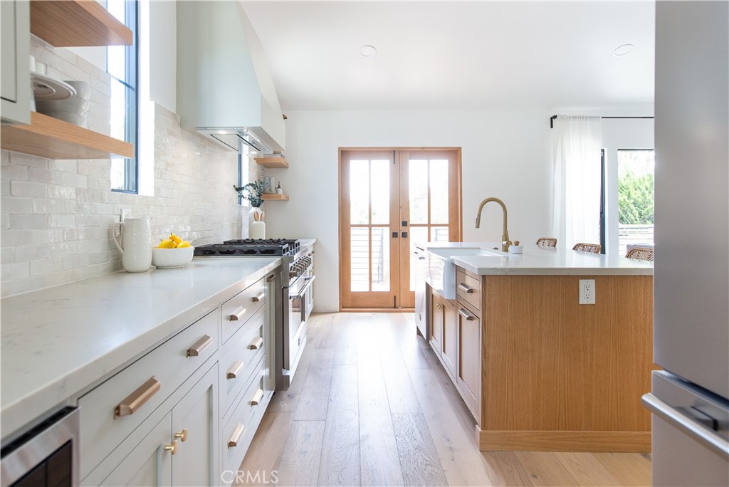 2372 Dewey Street Santa Monica, CA 90405 - Photo 8 of 22 a kitchen with stainless steel appliances a sink a counter space wooden floor and a window