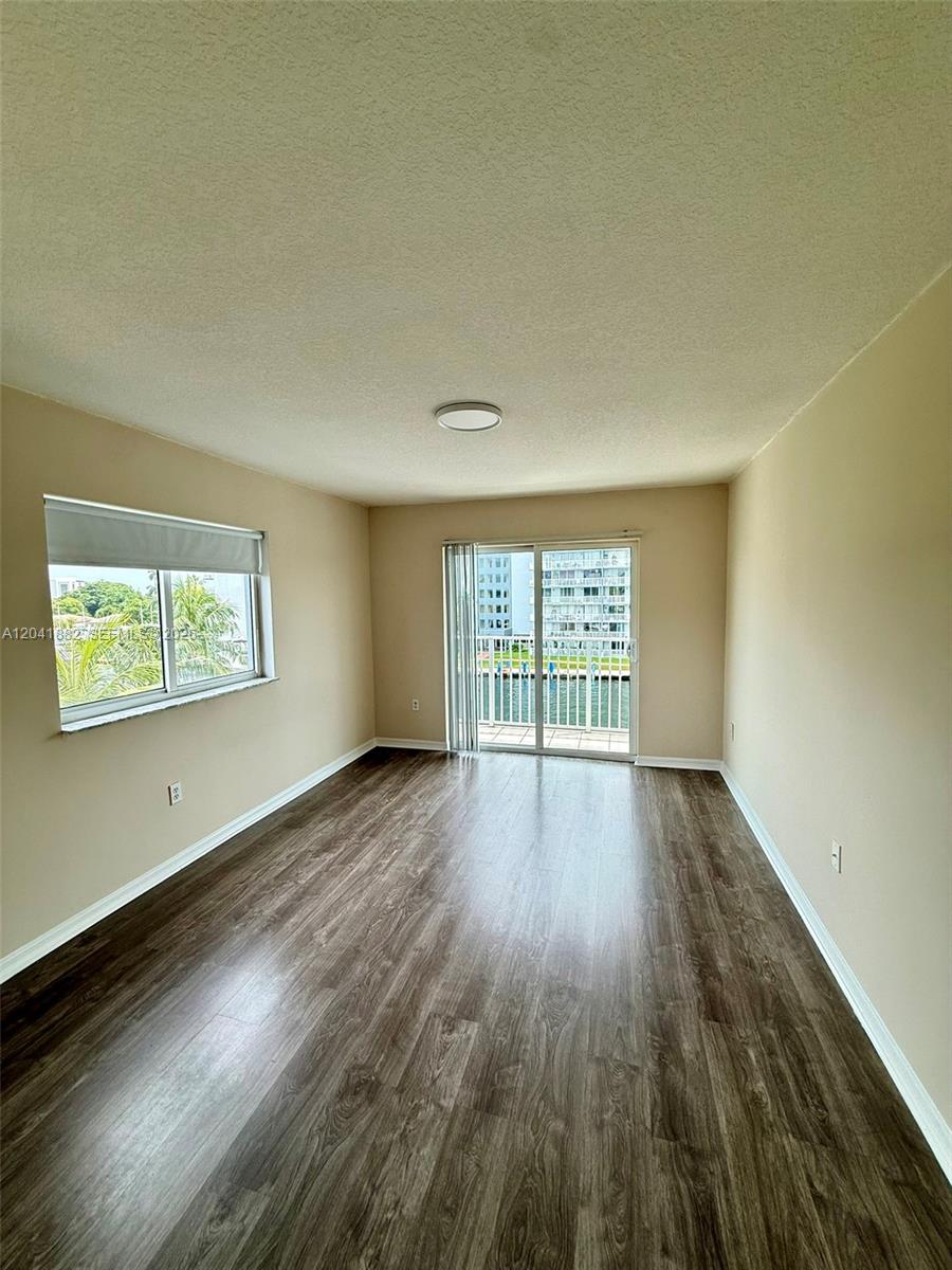 2475 Northwest 16th St Road, Unit 418 Miami, FL 33125 - Photo 14 of 27 wooden floor in an empty room with a window