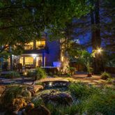 a view of swimming pool with lawn chairs and plants
