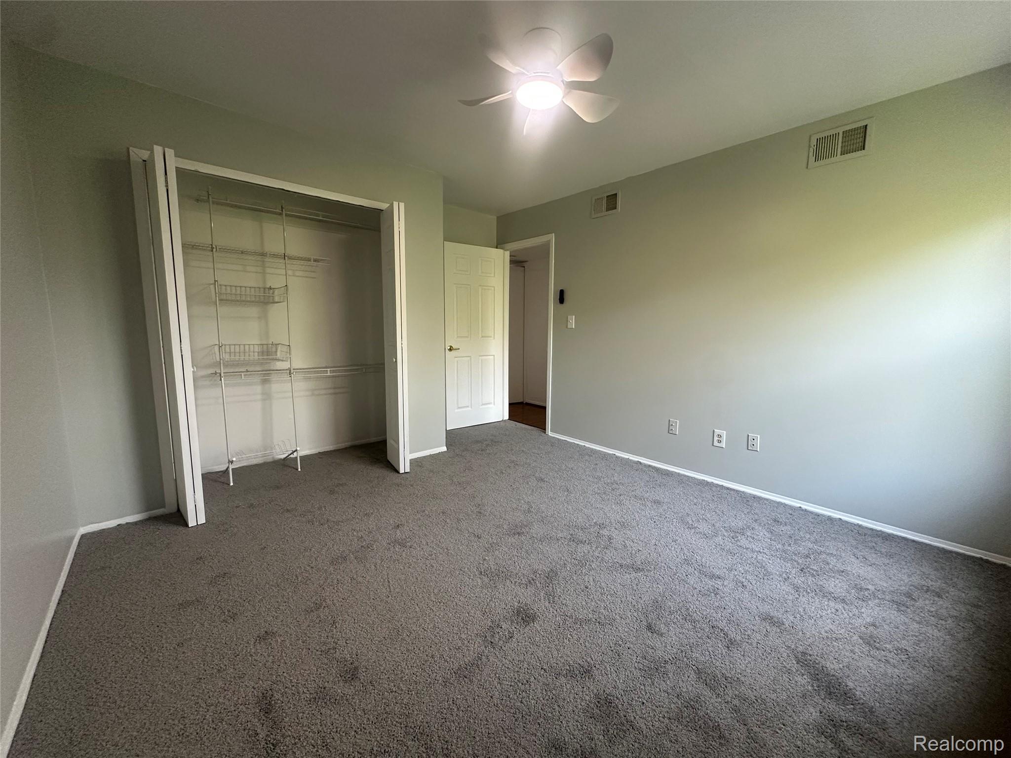 509 East University Drive Rochester, MI 48307 - Photo 14 of 20 Unfurnished bedroom with a closet, carpet floors, and a ceiling fan