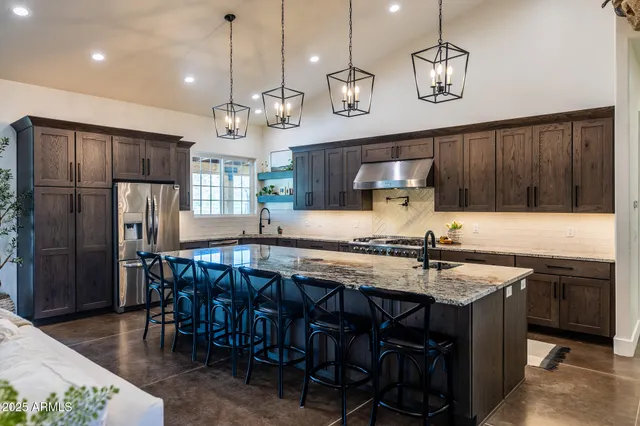 a kitchen with a table chairs stainless steel appliances and cabinets