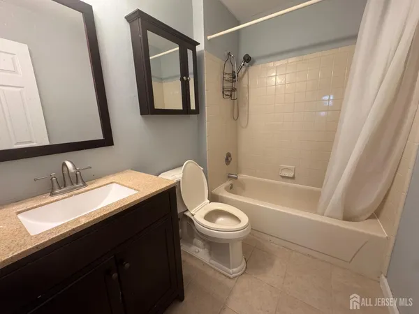 a bathroom with a sink a toilet a mirror a vanity and bathtub