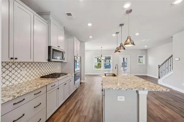a large kitchen with granite countertop a lot of counter space and wooden floor