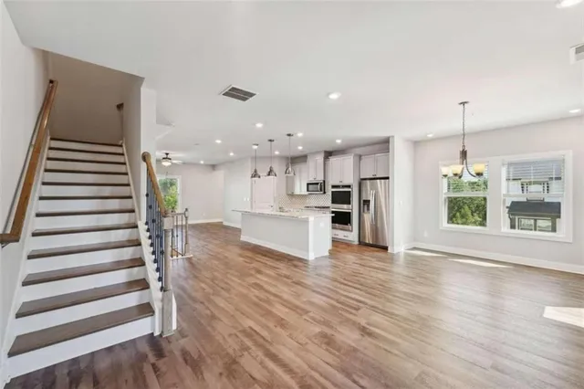 a view of a kitchen with wooden floor and windows