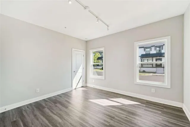 an empty room with wooden floor and windows