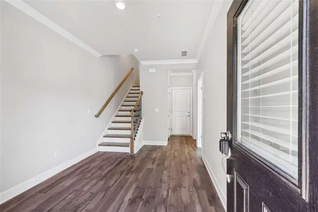 a view of a hallway with wooden floor and staircase