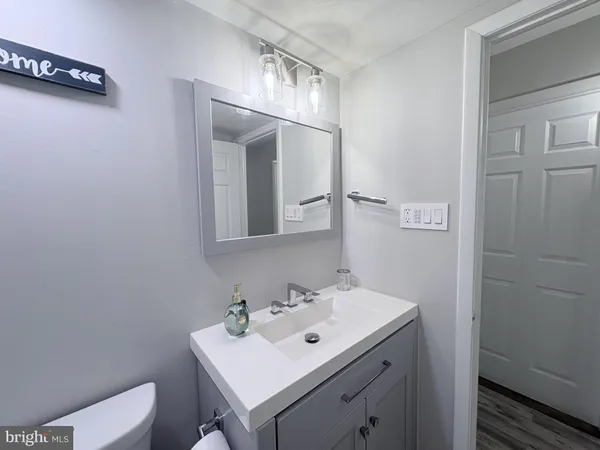 a bathroom with a sink a toilet and mirror