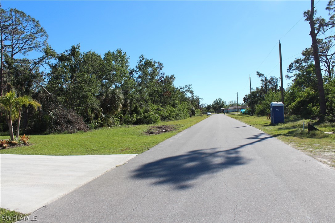 119 Blue Road Rotonda West, FL 33947 - Photo 5 of 6 a view of a street with a yard and trees