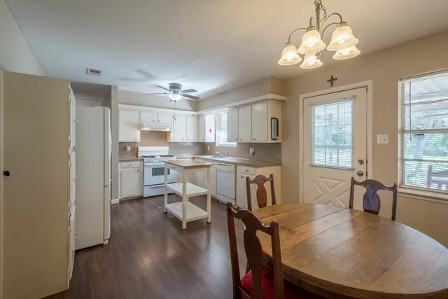 a open dining room with kitchen island stainless steel appliances furniture a chandelier open kitchen view