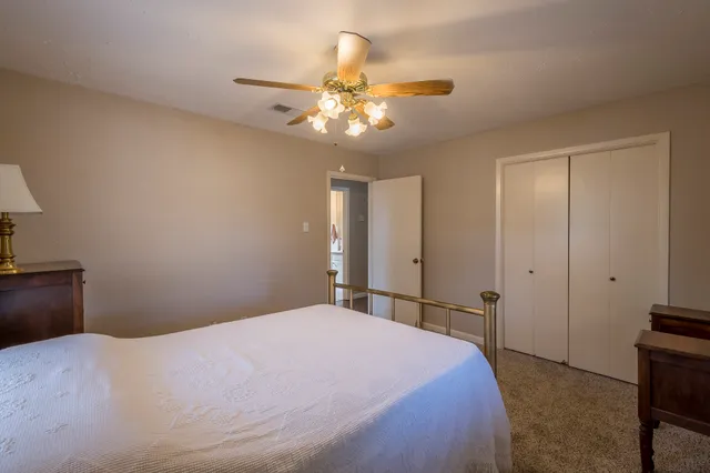 a bedroom with a large bed and a chandelier