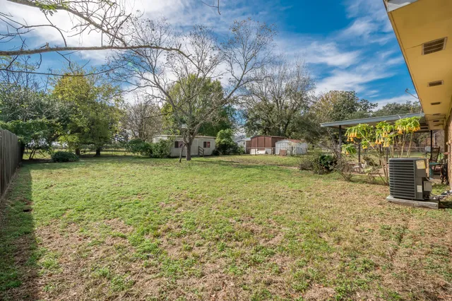 a view of a backyard with a garden and entertaining space