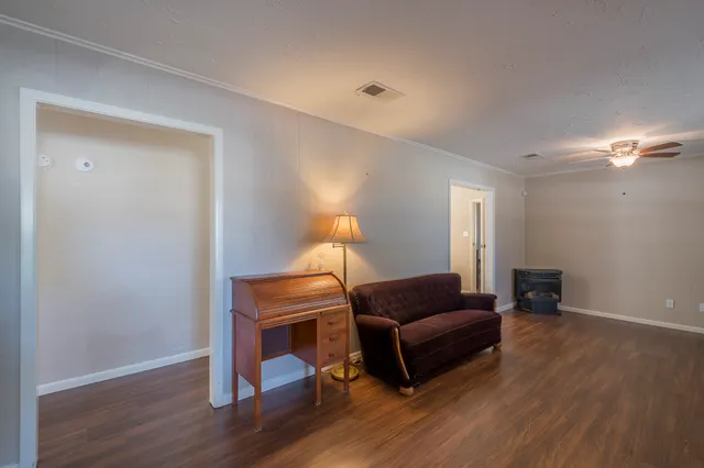 a living room with furniture and a wooden floor