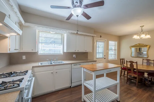 a kitchen with a stove a sink a dining table and chairs
