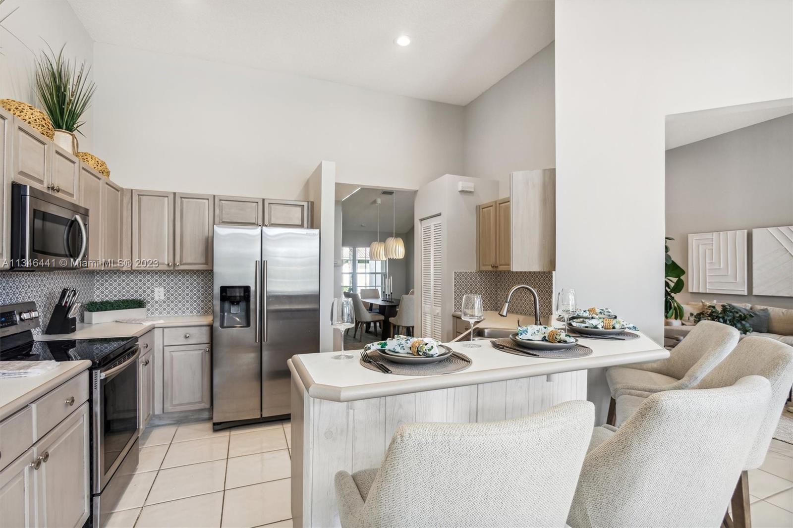 2883 Oakbrook Drive Weston, FL 33332 - Photo 44 of 74 a kitchen with stainless steel appliances kitchen island granite countertop a sink and cabinets