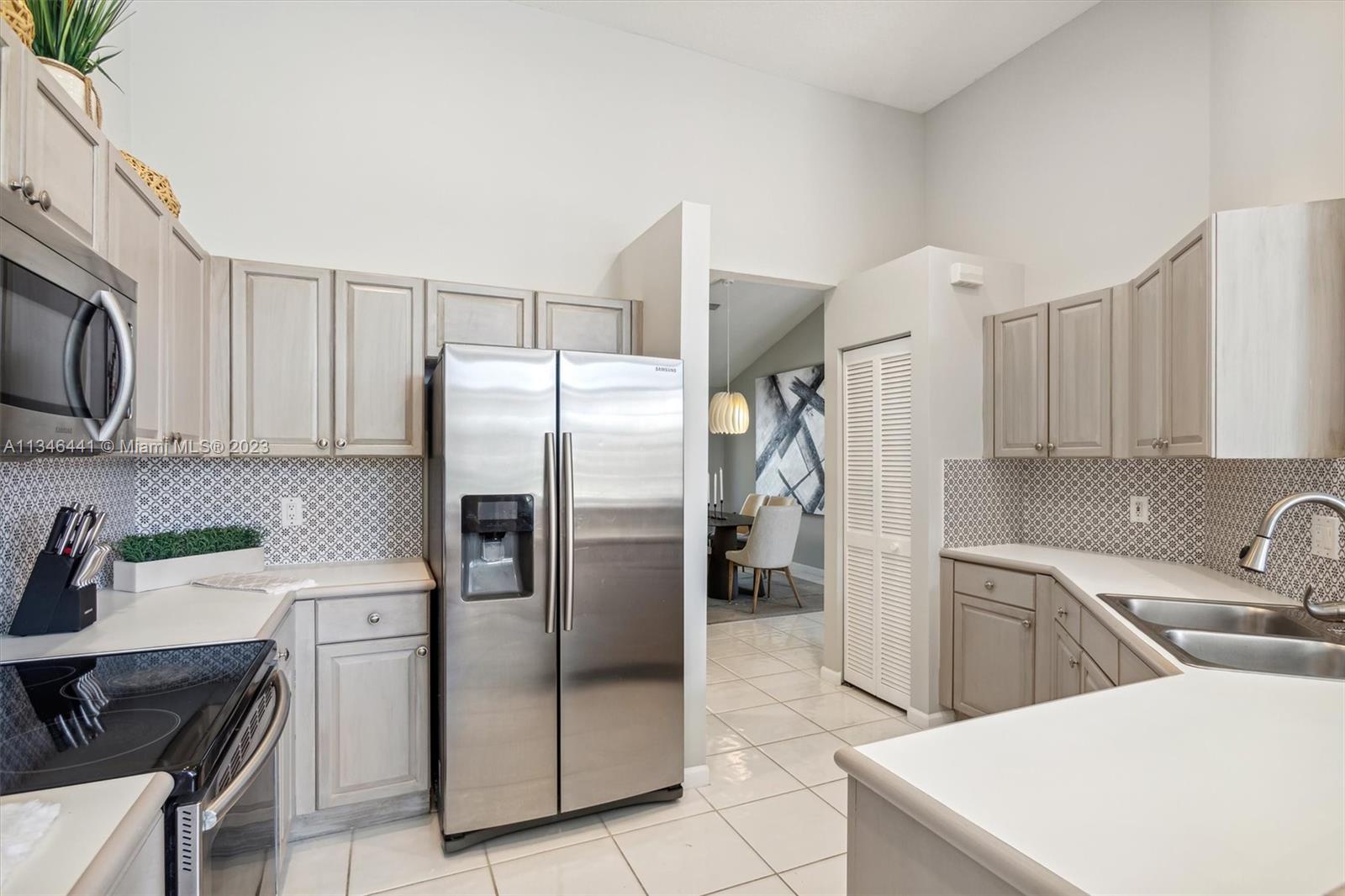 2883 Oakbrook Drive Weston, FL 33332 - Photo 45 of 74 a kitchen with stainless steel appliances a refrigerator sink and stove