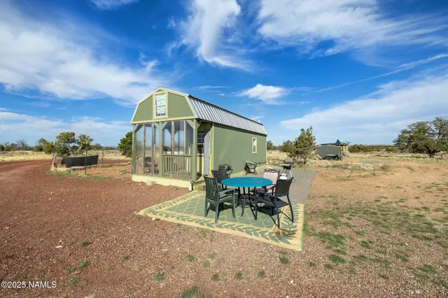 a view of a patio with a table and chairs under an umbrella