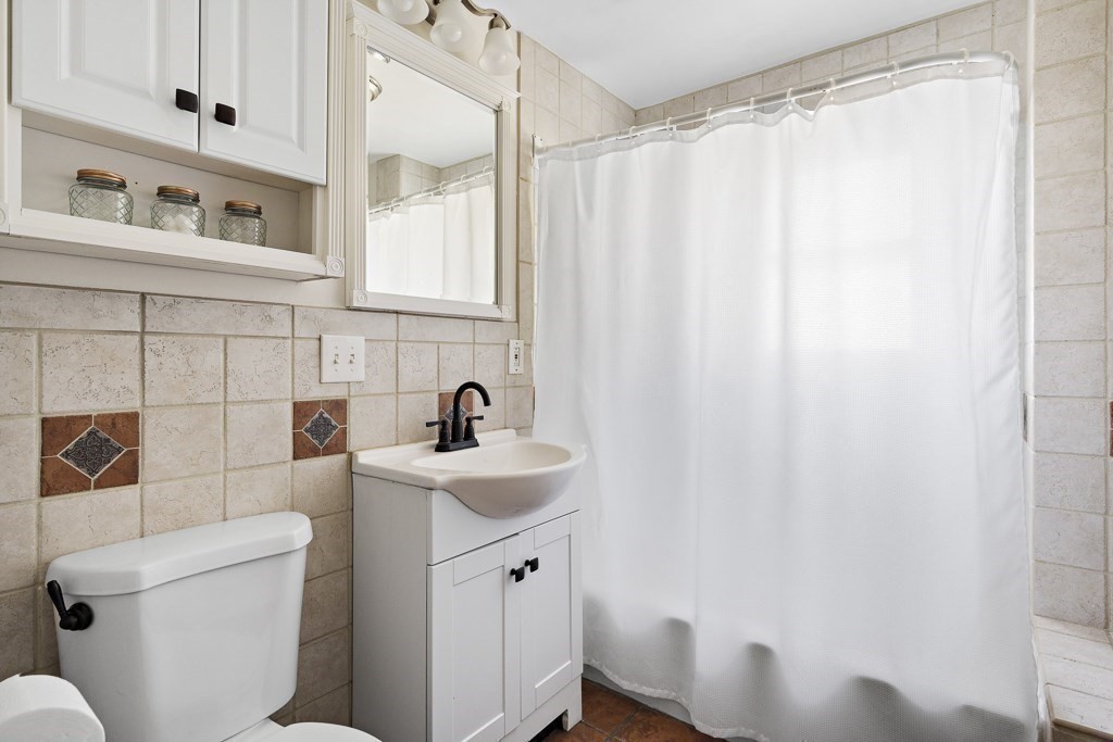 98 Summit Street Weymouth, MA 02188 - Photo 17 of 31 a bathroom with a sink a toilet and shower curtain
