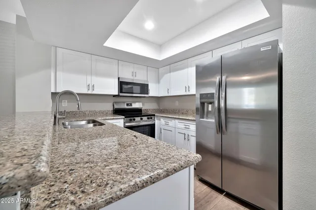 a kitchen with kitchen island a counter top space cabinets stainless steel appliances and a counter space
