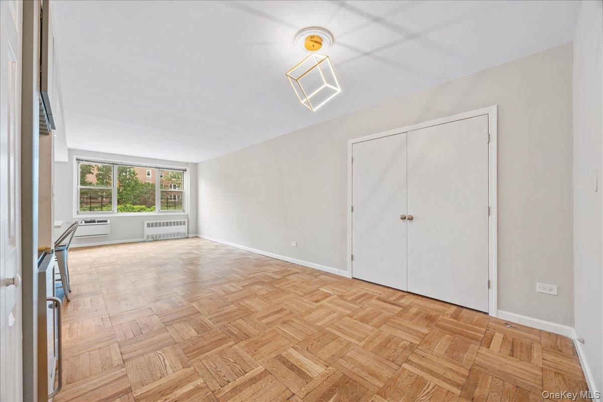 629 Kappock Street, Unit 2A Bronx, NY 10463 - Photo 14 of 36 Unfurnished living room featuring radiator heating unit and a wall unit AC