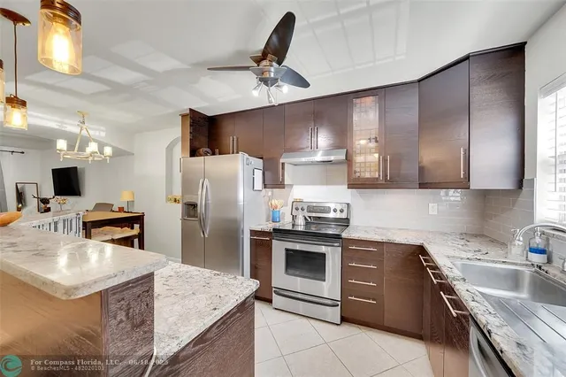 a kitchen with stainless steel appliances granite countertop a sink stove and refrigerator