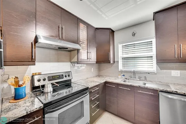 a kitchen with stainless steel appliances granite countertop a sink stove and cabinets