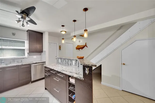 a kitchen with stainless steel appliances granite countertop a sink dishwasher and a stove with wooden floor