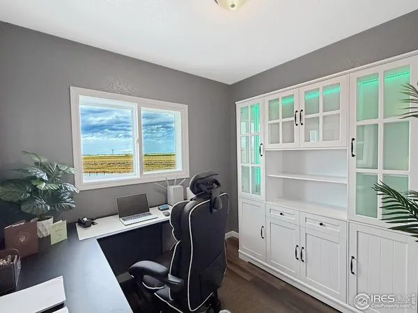 a view of a workspace with furniture and a window