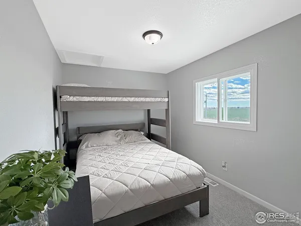 a bed sitting in a bedroom next to a window