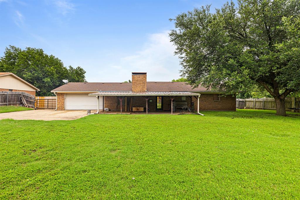505 Pinewood Lane Hewitt, TX 76643 - Photo 30 of 38 Expansive backyard featuring a large green lawn, mature shade tree, and wood privacy fencing