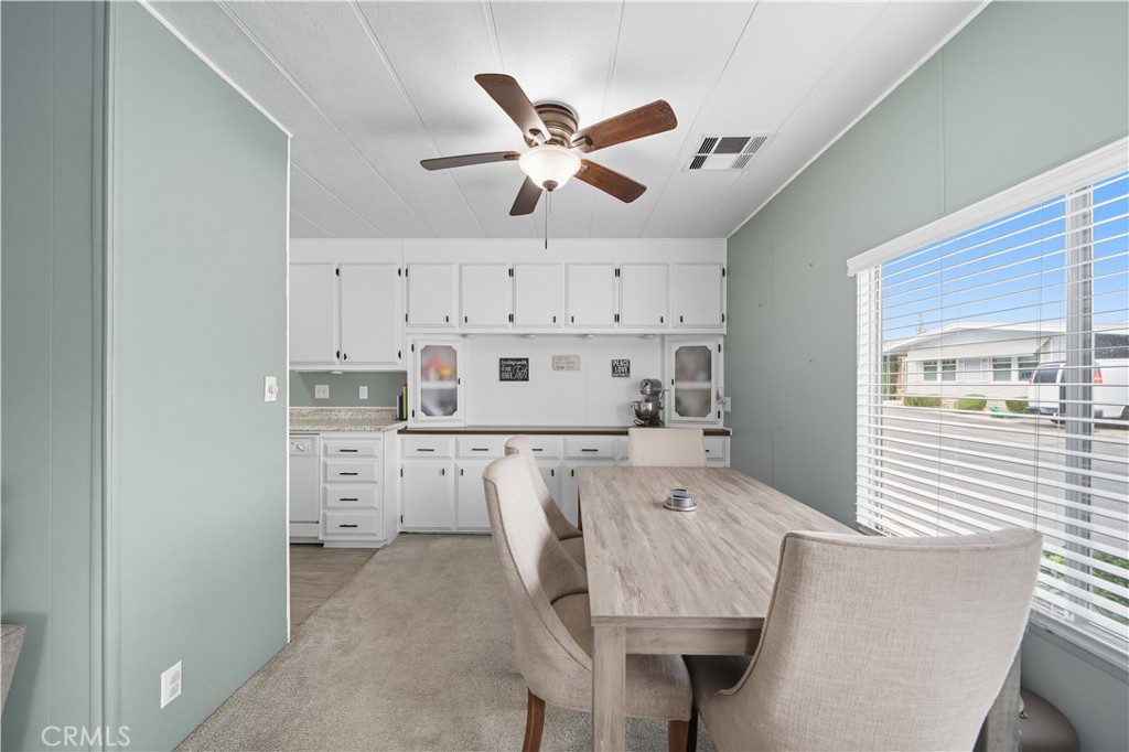 9800 Base Line Road, Unit 79 Rancho Cucamonga, CA 91701 - Photo 7 of 31 a kitchen with stainless steel appliances a stove a refrigerator and white cabinets