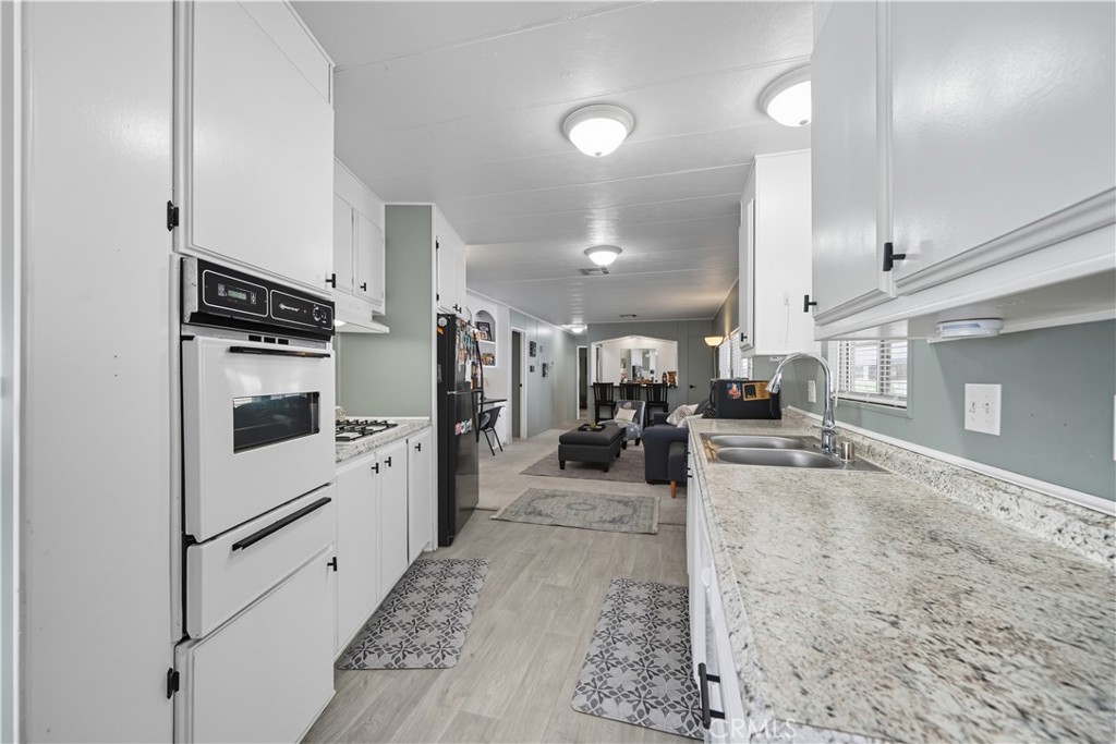9800 Base Line Road, Unit 79 Rancho Cucamonga, CA 91701 - Photo 8 of 31 a kitchen with stainless steel appliances kitchen island granite countertop a refrigerator a stove and a sink