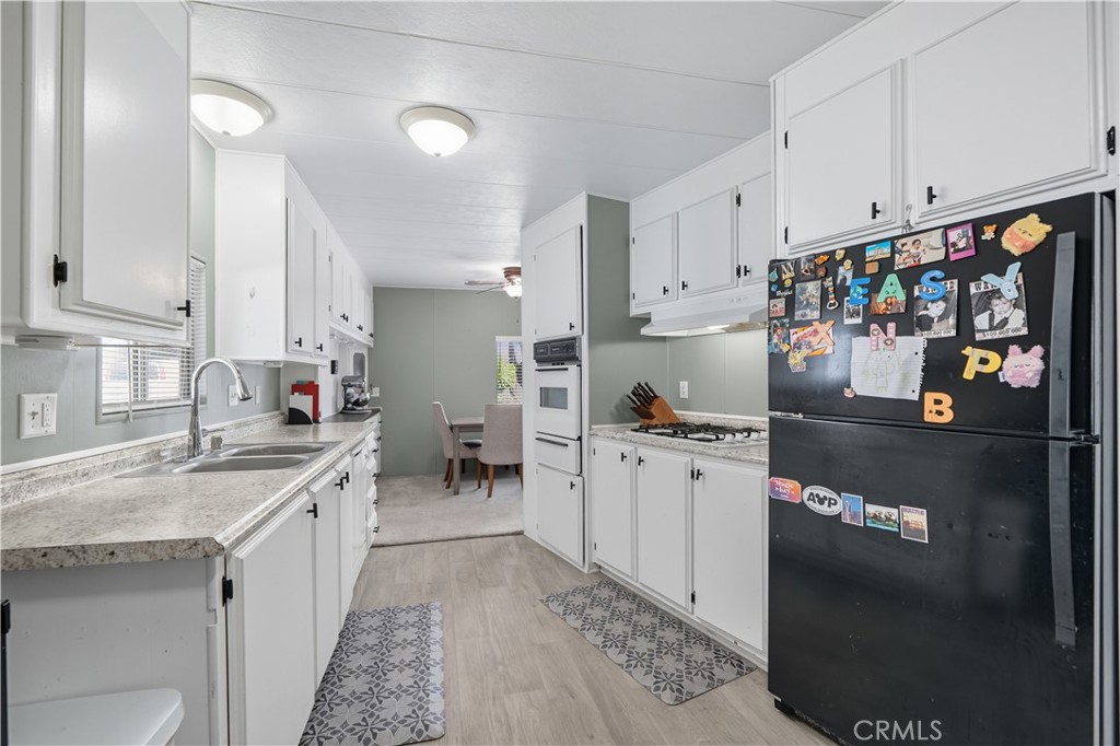 9800 Base Line Road, Unit 79 Rancho Cucamonga, CA 91701 - Photo 10 of 31 a kitchen with stainless steel appliances granite countertop a sink stove and refrigerator